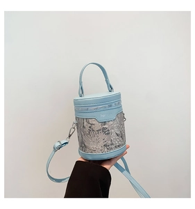 Detail of light blue bucket bag with intricate floral embroidery on mesh and PU leather