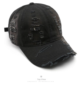 Detailed top view of a distressed black cotton baseball cap with vintage frayed edges