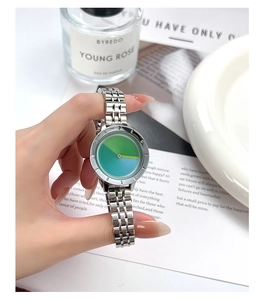 Detailed view of the silver mesh band watch with a gradient blue-green minimalist dial