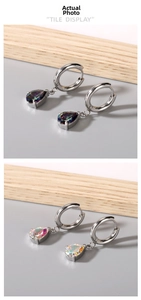 Detail of silver hoop earrings with iridescent pear-cut stones in a minimalist design