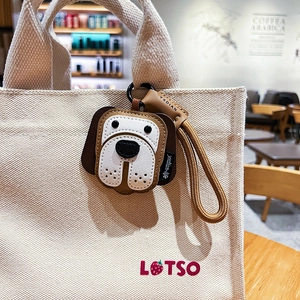 Handcrafted leather dog keychain accessory hanging on a canvas bag in a cafe setting