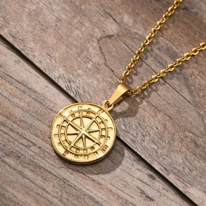 Makroaufnahme des Gold-Kompass-Anhängers auf Holz zeigt Vintage-Textur und Metallglanz