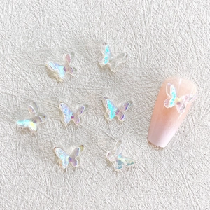 Macro detail of 3D iridescent resin butterfly charms for nail art on white background