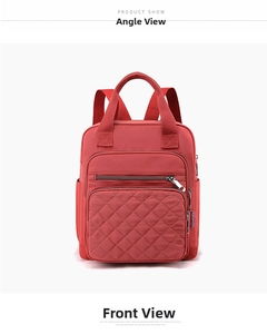 Close-up of red nylon backpack featuring quilted diamond pattern and multiple zipper pockets