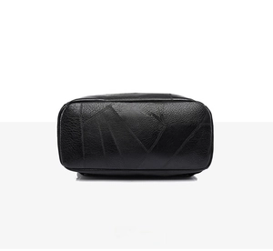 Dettaglio ravvicinato della base in pelle nera dello zaino con trama patchwork e cuciture