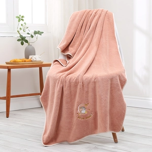 Detail of pink coral fleece towel featuring cute moon rabbit embroidery and soft texture