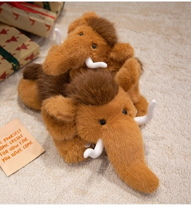 Detail of plush mammoth toys in brown faux fur with white tusks on a cozy beige rug