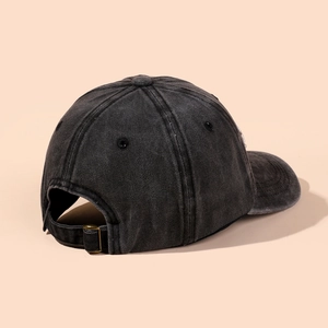 Detailed side view of washed black cotton baseball cap with adjustable metal buckle closure
