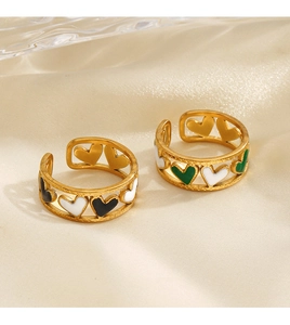 Détails macro de bagues dorées avec des motifs de cœur en émail coloré et design chic