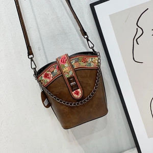 Detailed view of the dark coffee vintage bucket bag with elegant floral embroidery and chains
