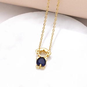 Macro shot of gold-plated necklace with a blue heart-shaped zircon pendant