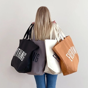 Detailed view of oversized canvas tote bags in black, grey, beige and brown finishes