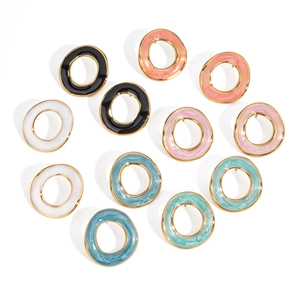 Détail de boucles d'oreilles créoles en émail coloré avec bordure dorée élégante