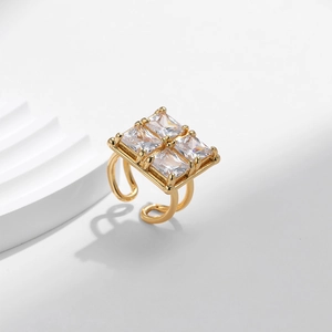Chic gold plated geometric square ring with four zircon stones on a white architectural base