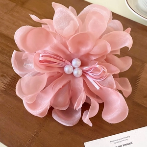 Detailed view of pink chiffon lace flower hair claw with pearl beads and ribbon bow