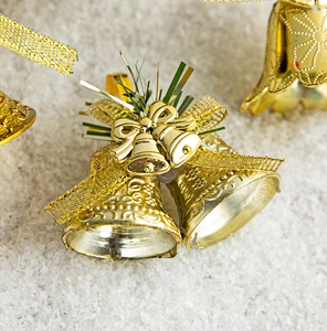 Detail view of golden Christmas bells with mesh bows and green pine needles decoration