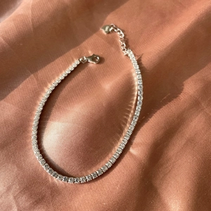 Detail view of S925 sterling silver adjustable tennis bracelet with lobster clasp on silk