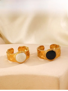 Detail of 18K gold plated hammered ring with white shell and black enamel inlay