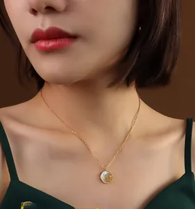 Close-up of gold rose pendant necklace with white mother of pearl inlay on model
