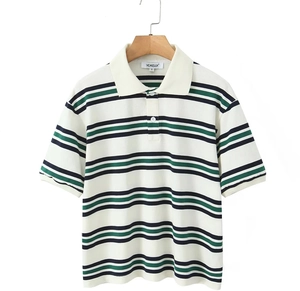 Détail d'un polo blanc pour homme avec rayures bleu marine et vertes sur un cintre
