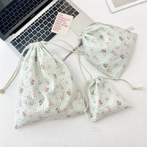 Close-up of three plaid drawstring storage bags with cartoon rabbit and bear prints