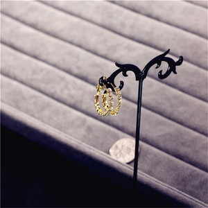 Detailed close-up of large golden crystal hoop earrings with sparkling rhinestones