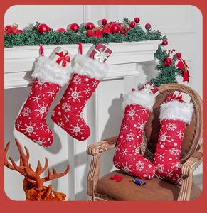 Detail of four red Christmas stockings with white snowflake embroidery and plush faux fur trim