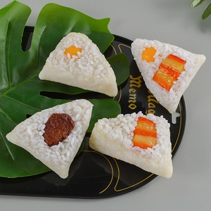 Set of four realistic PVC rice ball models with various toppings on a black display tray