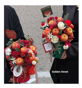 Detail of Christmas apple bouquet in red and green flower boxes with festive ornaments