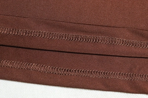 Detail shot of double-needle stitching on dark brown synthetic fabric with subtle sheen