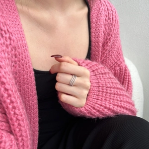 Close-up of a silver triple-band stacked ring worn by a model in a casual setting
