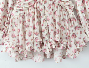 Detail of floral print chiffon dress with front buttons and layered ruffle hemline