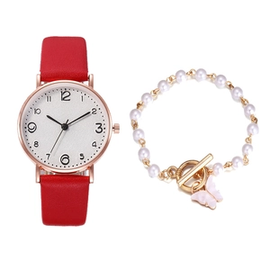 Detail of elegant red leather quartz watch paired with a gold pearl butterfly bracelet