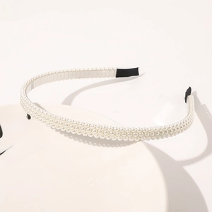 Close-up of triple-row pearl headband with silver metal frame and soft black rubber tips