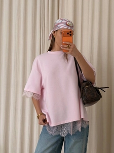 Mirror selfie showing a pink lace-trimmed t-shirt with delicate embroidery on the sleeves