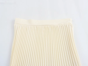 Detail shot of ivory pleated skirt featuring elegant texture and high-quality waist tailoring