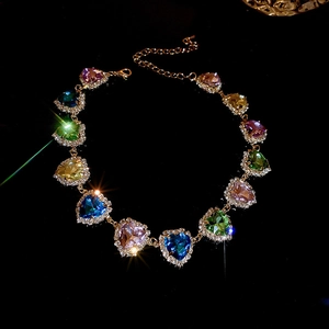 Dettaglio macro della collana di strass a cuore colorato con catena dorata regolabile