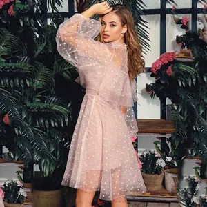 Elegant pink tulle maxi dress with white polka dots and long puff sleeves in a garden setting