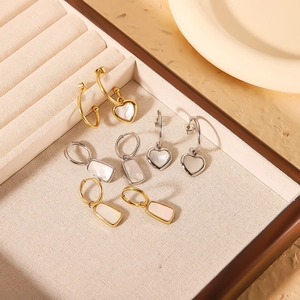 Golden and silver geometric heart earrings with natural shell inlay in a jewelry box