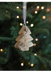 Detail of multi-layered wooden Christmas tree ornament with bark texture and white ribbon