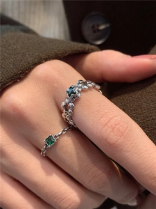Détail de bagues vintage en argent avec zircons vert émeraude et trèfle ajouré élégant