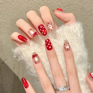 Handmade 3D red ribbon bow press-on nails with sparkling polka dots and festive patterns