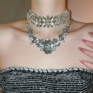 Close-up of sparkling rhinestone leaf choker and elegant grey crystal drop necklace set