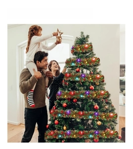 Family decorating Christmas tree with colorful glowing tinsel garlands for festive party