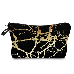 Detail of black marble makeup bag with gold veins, metal zipper, and side handle