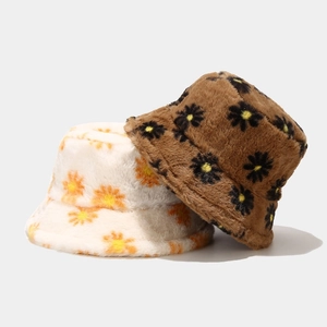 Detail shot of plush faux rabbit fur bucket hats featuring embroidered daisy patterns