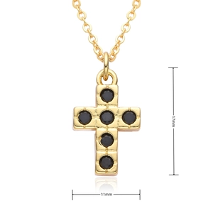 Detail view of 17mm gold cross pendant with black cubic zirconia on white background