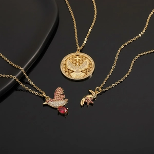 Gold eagle and dove pendant necklace set with colorful zircon stones on black background