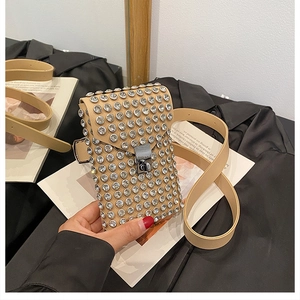 Detail of beige shoulder bag with sparkling rhinestones and metal buckle closure