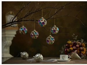 Detailed view of faceted glass Christmas ornaments with colorful sequins and metal trim